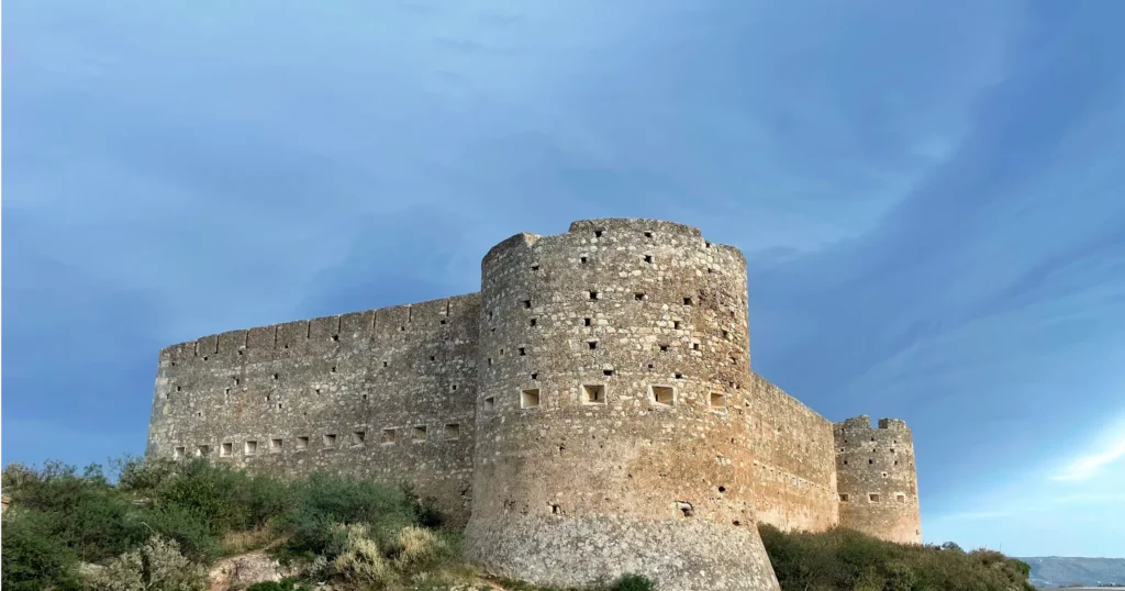 Aptera Castle Crete Greece, white stone turret and walls against a bright blue sky