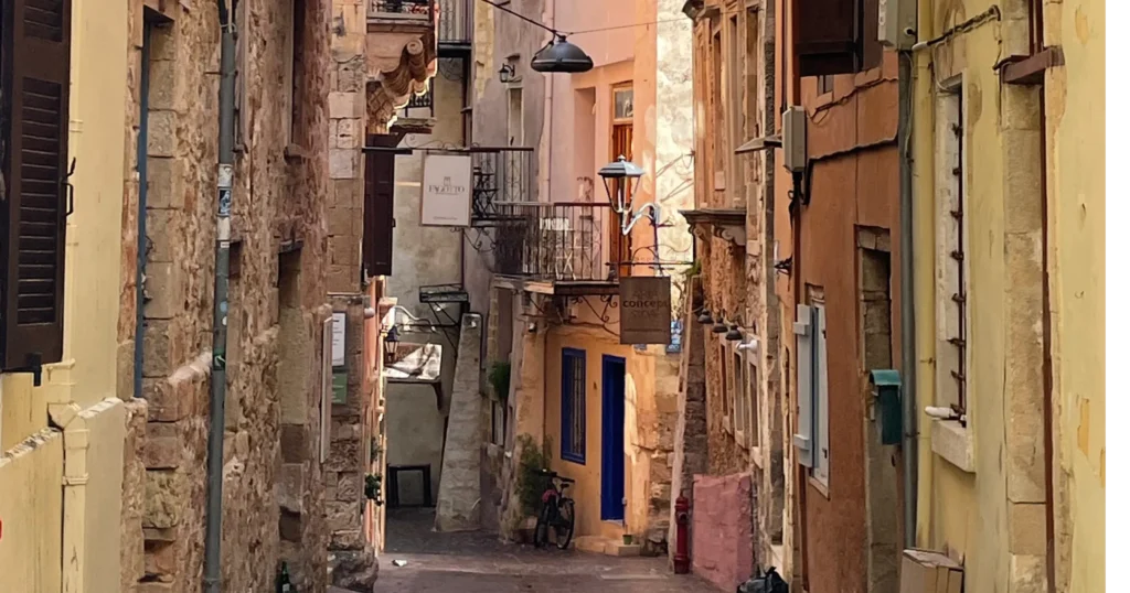 Street in Chania Greece with yellow and light red colored buildings and cobblestone street