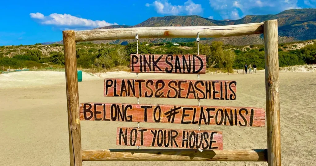 Elafonisi beach hanging wooden sign stating Pink Sand, plants and seashells belong to #Elafonisi, Not Your House