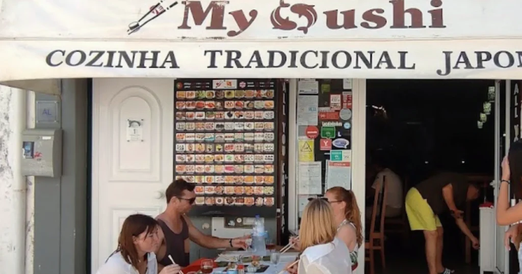 My Sushi Lagos Portugal image of My Sushi awning and front of restaurant with a table of four people dining