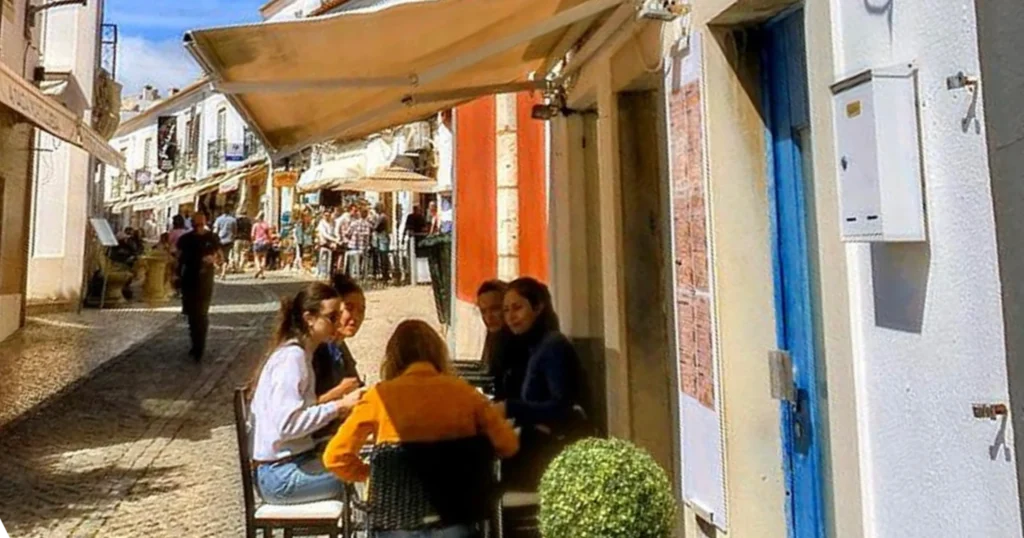Seven Hills Indian Restaurant Lagos Portugal image of people sitting at a table under an awning with street in the background