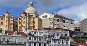 Lisbon city scene with colorful blue tile buildings and a domed church