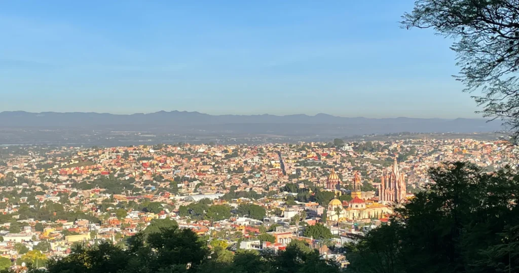 View from the Mirador in San Miguel de Allende the city and mountains in the distance with the Parroquia on the right side of the image