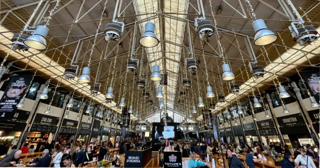 Timeout Market food hall image of high ceiling market with glass roof with tables in the middle full of people eating
