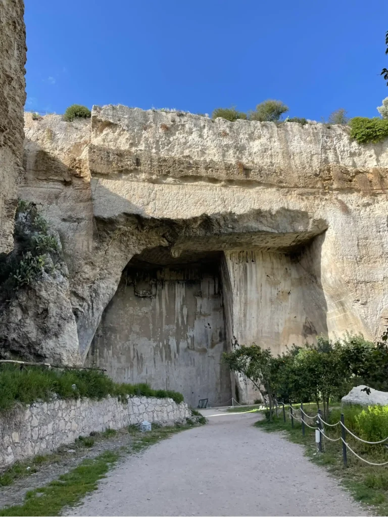 View of large stone wall and cutouts looking into the ancient quarry in the Neapolis Site in Syracuse Sicily