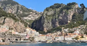 Best time to visit Amalfi town view from the ferry with colorful buildings built in a small area at the base of steep terrain