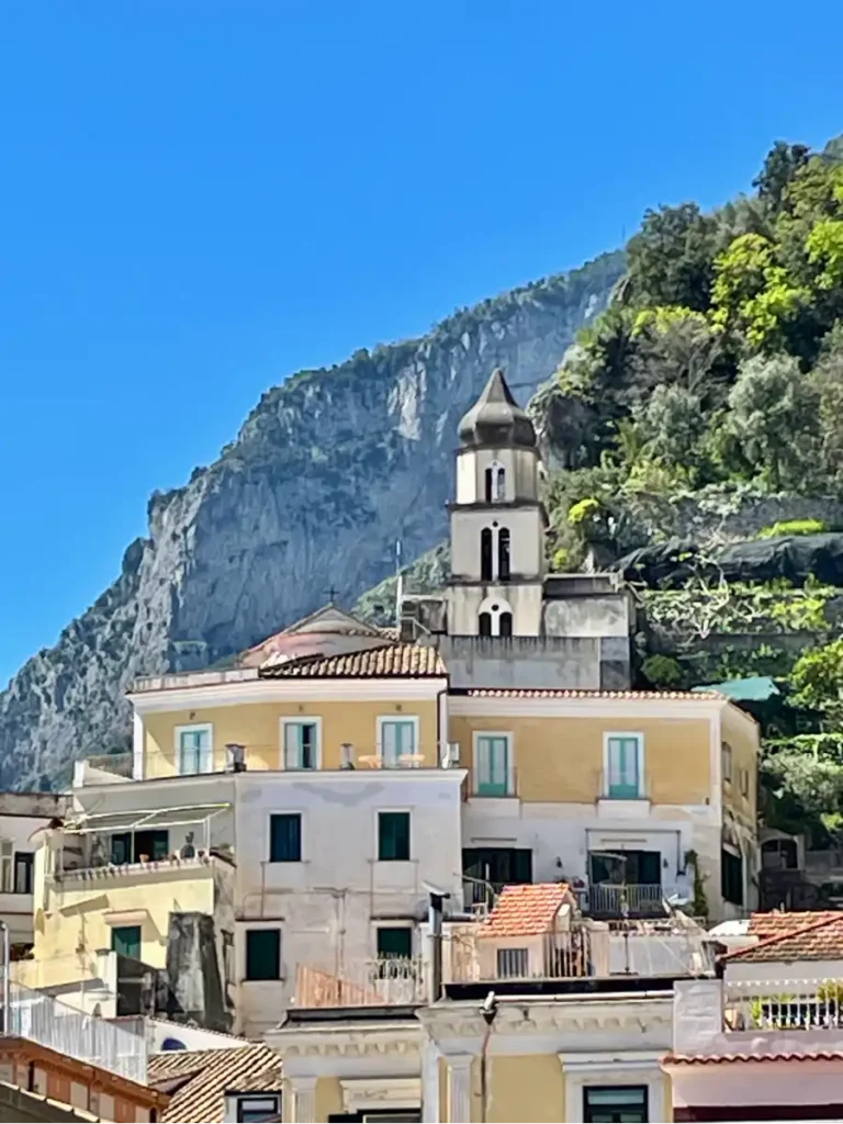 Amalfi church steeple and buildings with a cliff in the background
