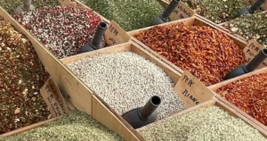 Colorful grains, spices and frech ingredients in open wooden crates on a table at a Sicilian fresh food market