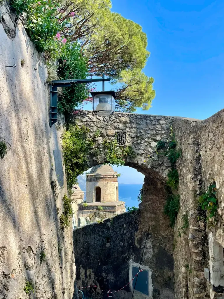 Stone archway with green tree above in Amalfi