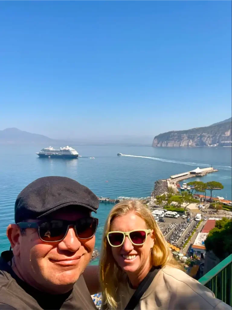 Selfie of two traveling after one over looking the Amalfi coast with a cruise ship in the background