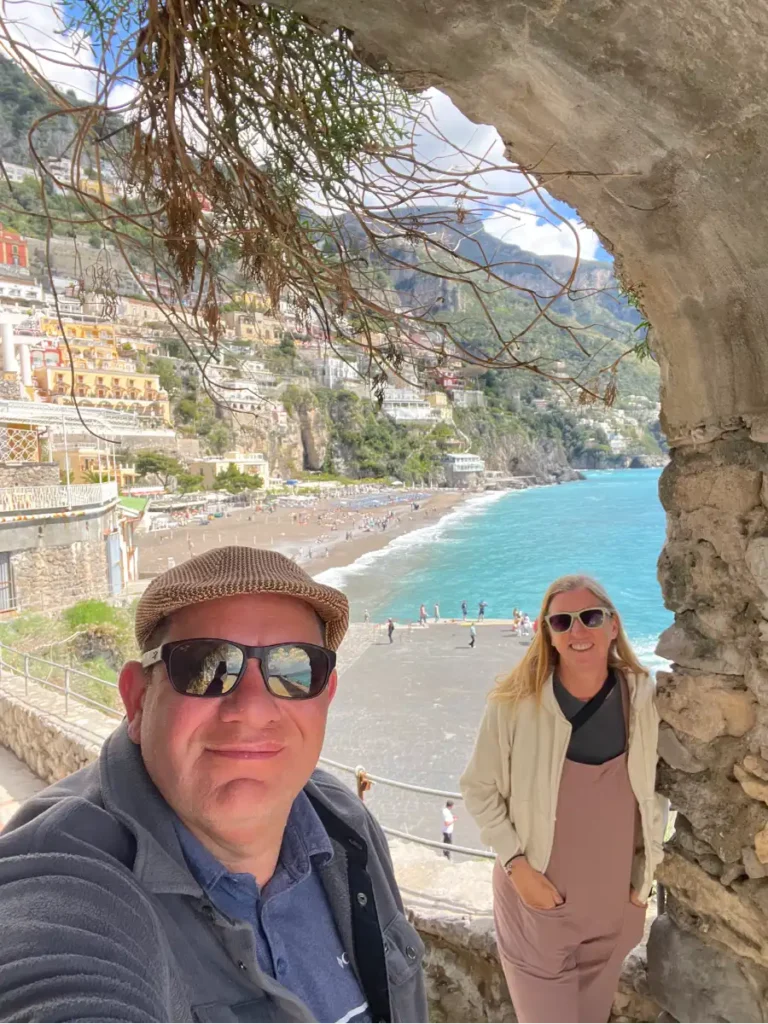 selfie with the Positano beach in the background taken in a stone archway