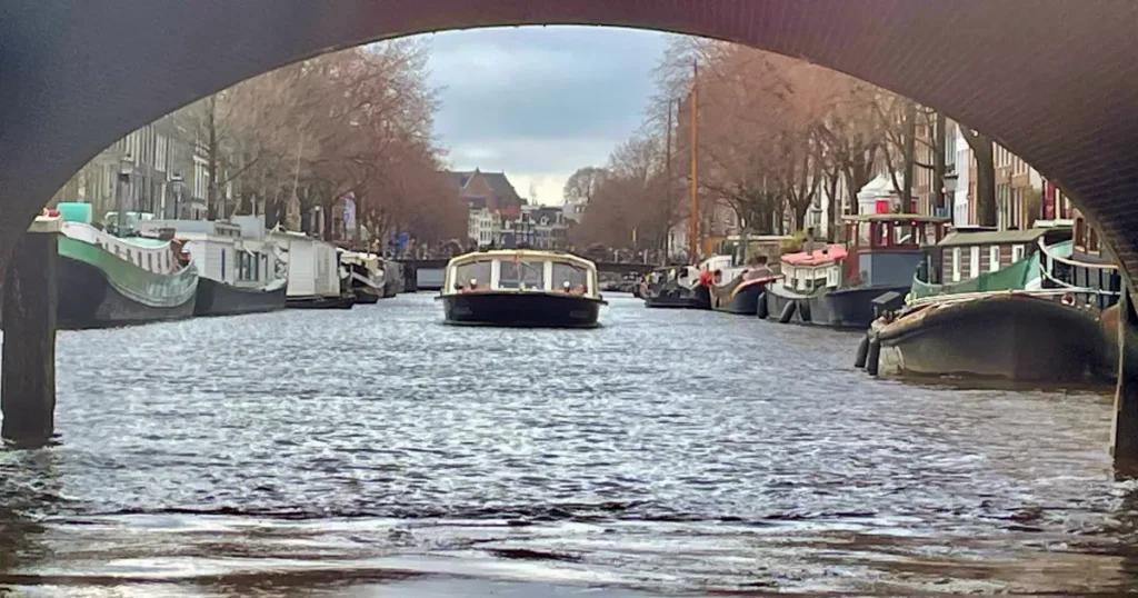 Looking through a bridge on a canal with a boat in the background