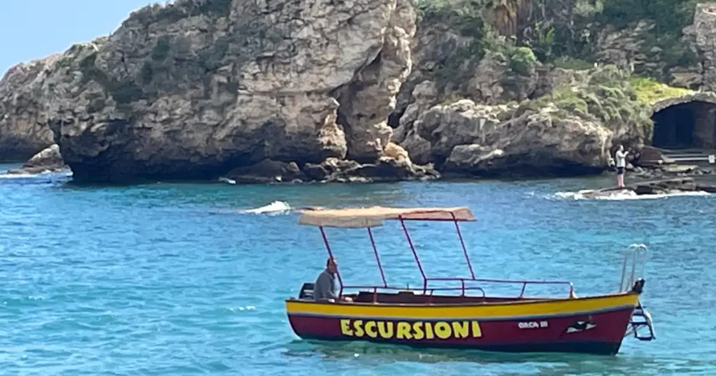 Red boat with yellow lettering saying Excursions