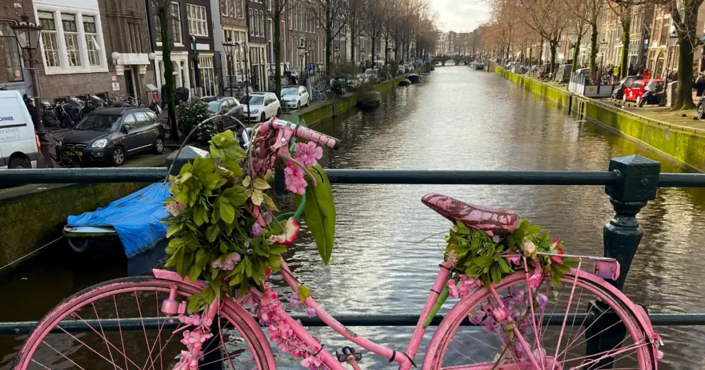 Pink bike on bridge over canal in Amsterdam