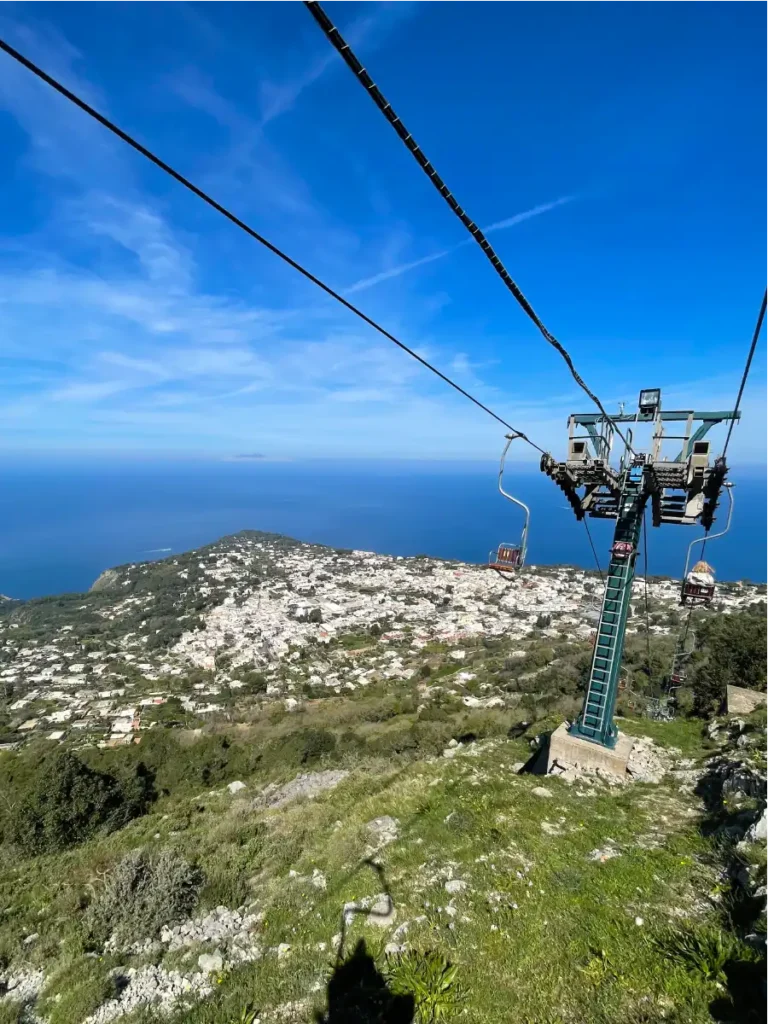 View from the Mt Solaro chairlift green hill below and deep blue sea in distance