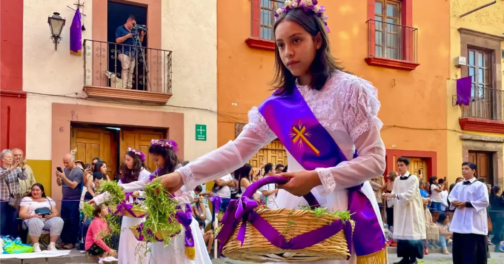 Girl tossing flowers from a basket during the santa de semana in san miguel de allende