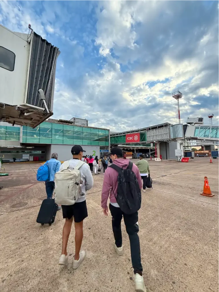 People walking across the tarmac into the airport after deplaning