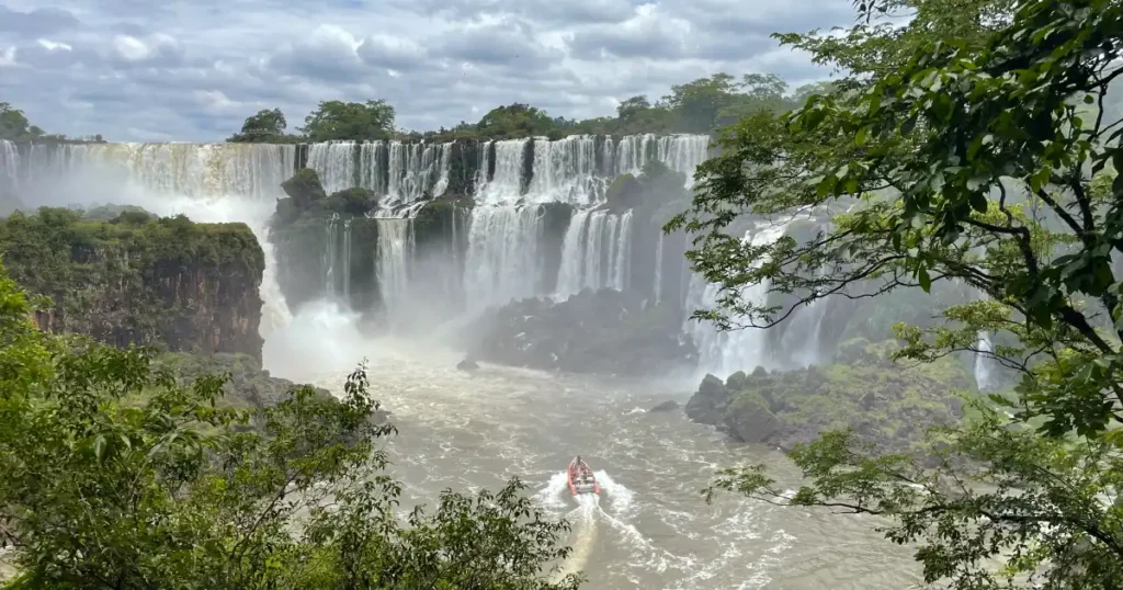 Lower Trail View of Iguazu Falls with small Boat in Image approaching Iguazu Falls from the Loer Trail