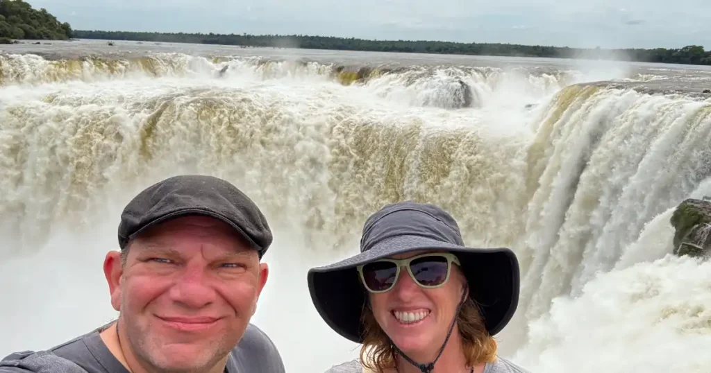 Photo of Dan and Meghan at top of Devis Throat at Iguazu Falls with Raging Falls in Background