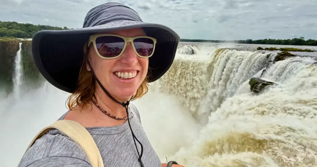 Photo of Meghan at top of Devil Throat Iguazu Falls with Falls in Background