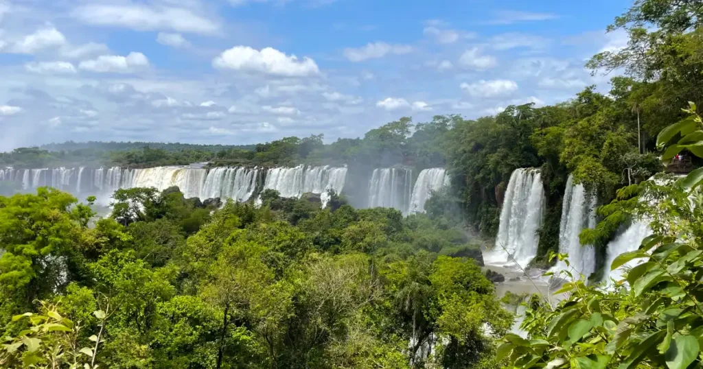 Wide angle view of a large number of falls from lower Trail on Argentina side with slight cloud cover