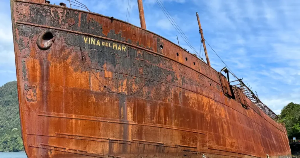 Rusting Shipwreck of the Vina Del Mar in Chacabuco Harbor next to a number of small boats