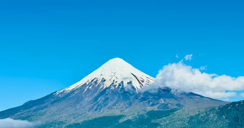 Snow capped Orono Volcano view from Lake Todo Santos in Chile with small cloud